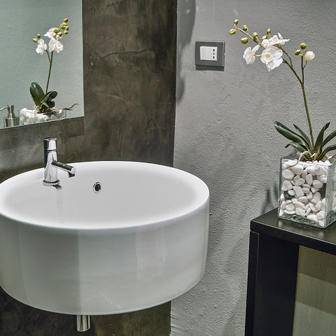 Spa bathroom with white sink and white orchid flower