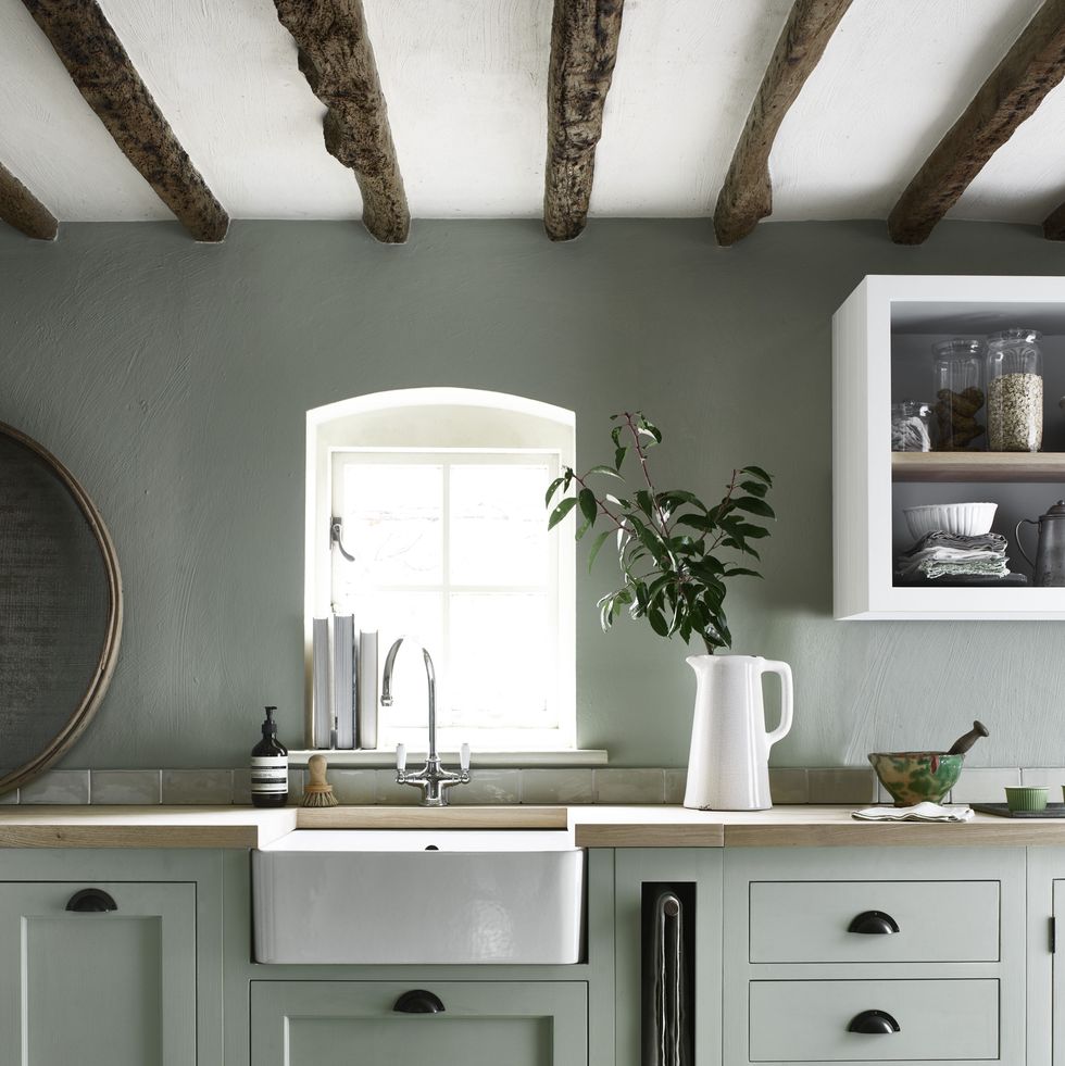 Pretty country cottage kitchen with moss green kitchen cabinets with black nickel cup pulls. 