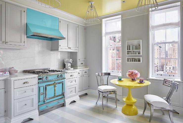 Blue and yellow kitchen with satin nickel cabinet hardware on white cabinets