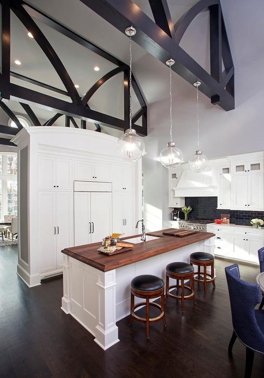 This architectural beauty of a kitchen features medium cabinet pulls mounted on pantry doors that frame the refrigerator. 