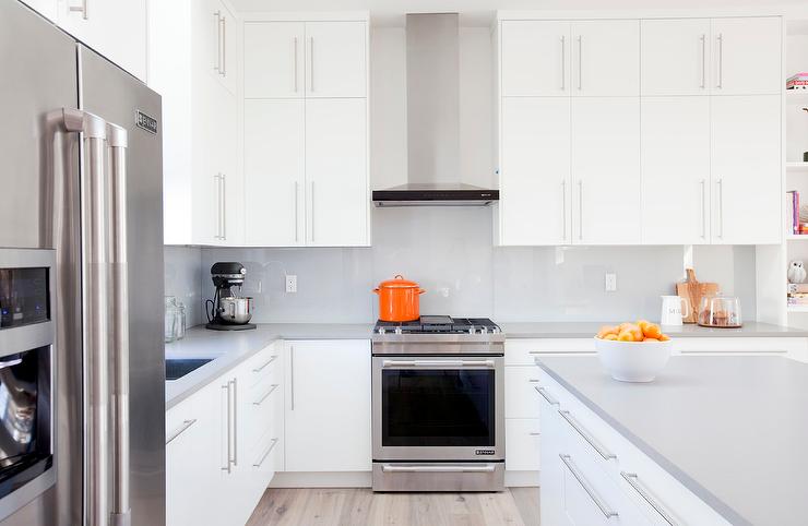 This clean and bright kitchen features a ton of upper cabinet storage with long bar pulls. 