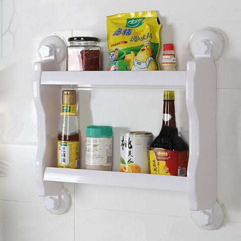 Condiments and sauces on a white suction shelf stuck to white kitchen wall