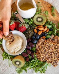 Plate of plant-based foods with crackers and hommus 