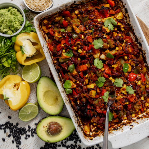 Overhead shot of a dish of Mexican Ratatouille with ingredients spread on the table