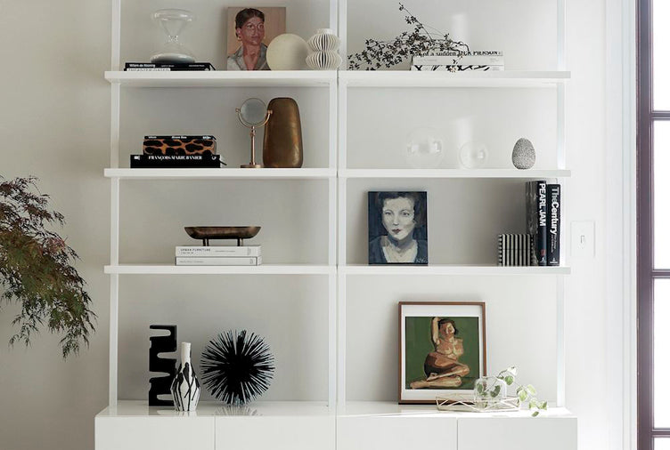 Minimalistic white bookshelf with paintings