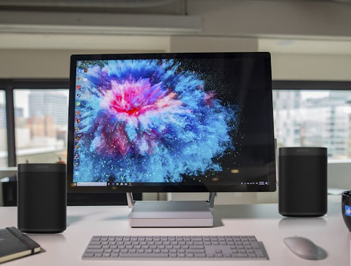 Sonos One speakers next to computer desktop