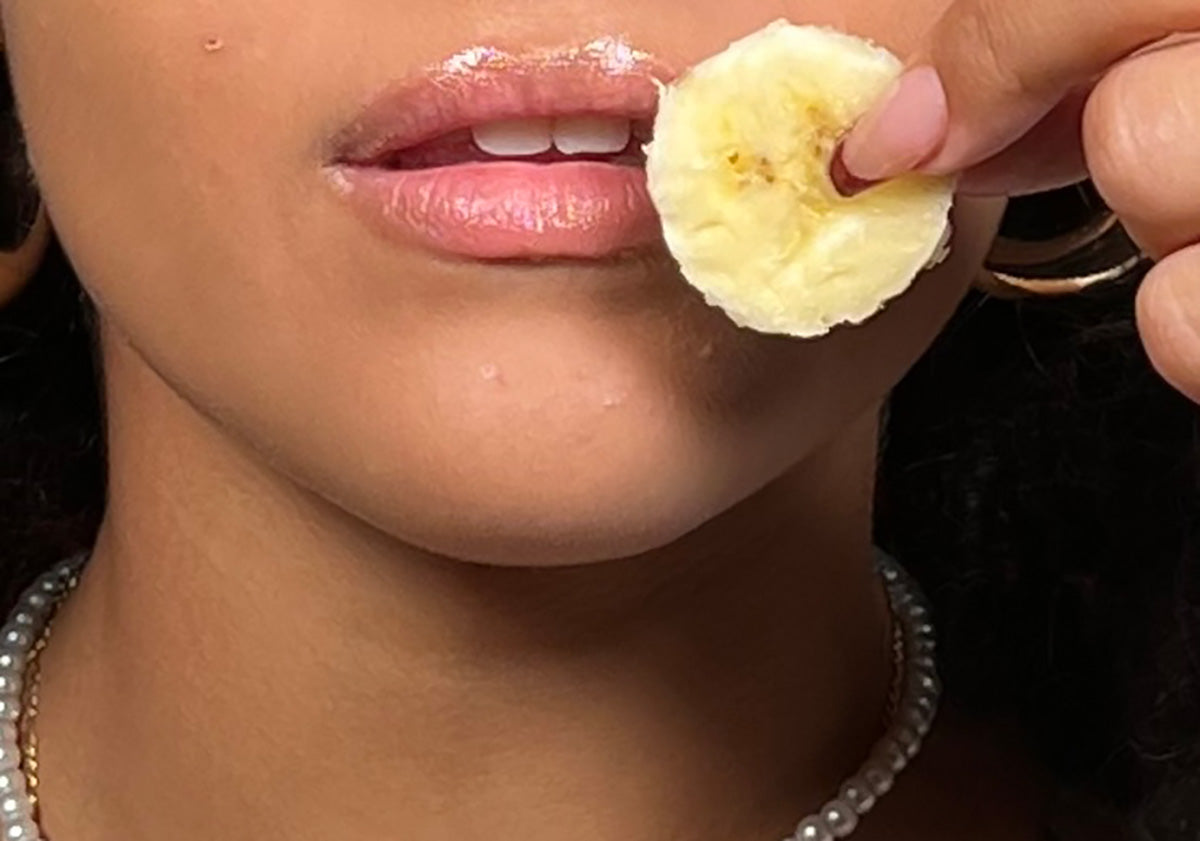 image of a woman holding a slice of banana near her lips