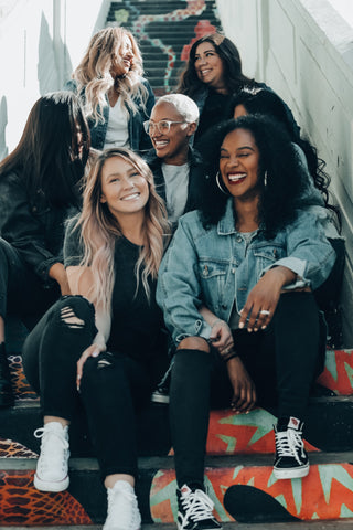 multiple women sat on a staircase together