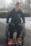 Logan in his wheelchair outside with snow in the background.