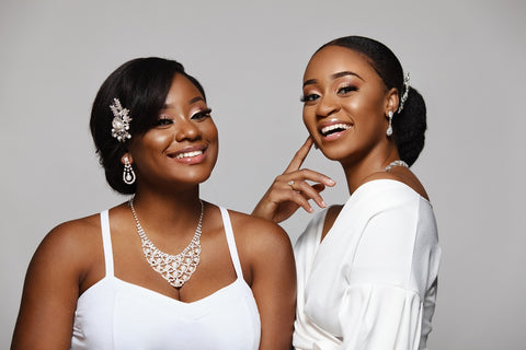 2 black women modelling various bridal jewelry pieces - hair accessory, necklace, earrings
