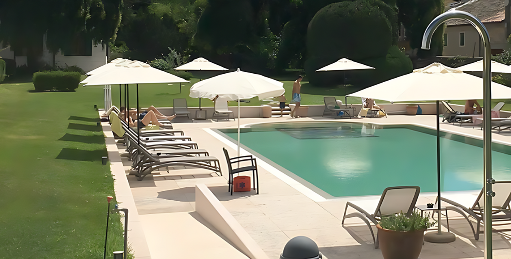 Villa Nichesola, Italia | Regadera independiente de acero inoxidable grado marino, modelo Cometa, junto a una alberca en un día soleado.