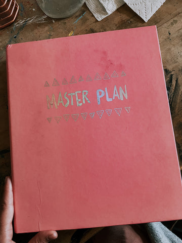 Pink three ring binder with decoration that says Master Plan 