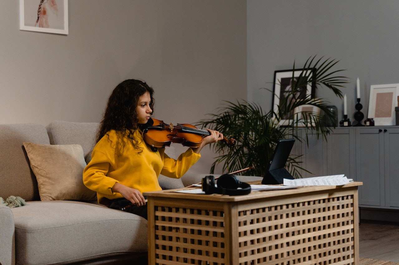 girl playing violin at home