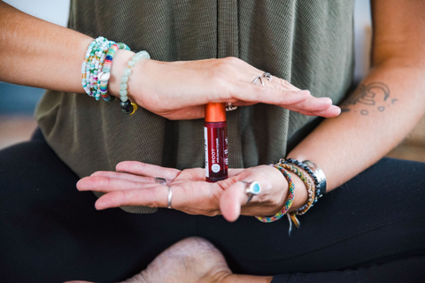 A person holding the root chakra roller in their hands