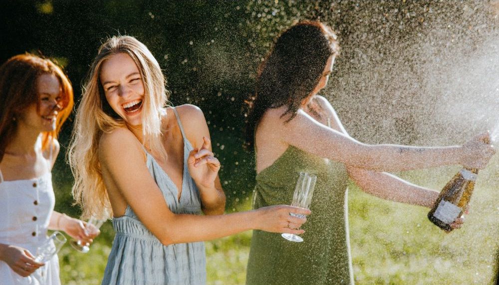 Girls popping a bottle of champagne at a Bridal Shower