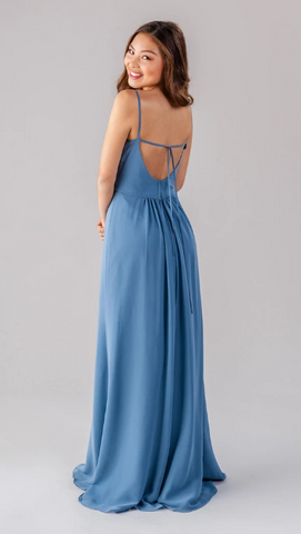 Kennedy Blue model wearing elegant dress with a bateau neckline and side slit. 