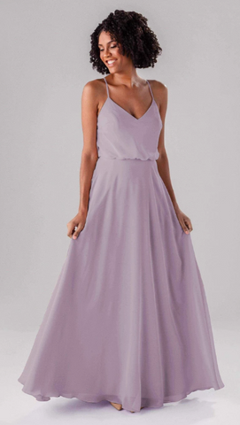 Kennedy Blue model wearing a whimsical flowy dress with a v-neckline and chiffon skirt. 