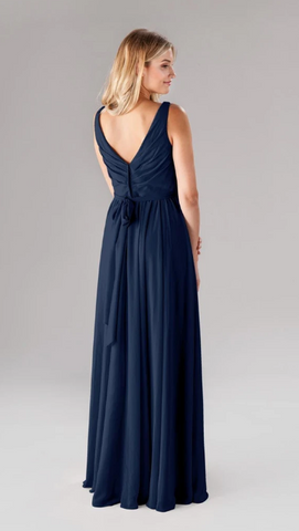 Kennedy Blue model wearing an elegant gown with a pleated ruched bodice and a flowy skirt.
