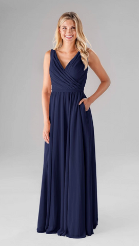 Kennedy Blue model wearing an elegant gown with a pleated ruched bodice and a flowy skirt.