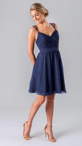 Kennedy Blue model wearing a pretty knee-length dress with a ruched bodice and criss-cross back design.