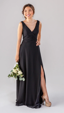 Kennedy Blue model wearing a sophisticated gown with a v-neckline, ruched bodice, and a side slit.