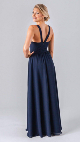 Kennedy Blue model wearing an elegant dress with a low v-neckline and an A-line skirt with a side slit.