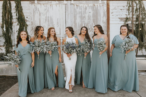 Bride and Bridesmaids walking as they look around and smile at each other. 