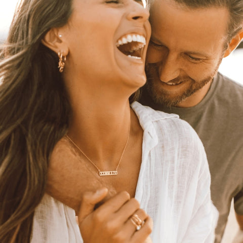 happy couple smiling after receiving a necklace for valentines day 2022