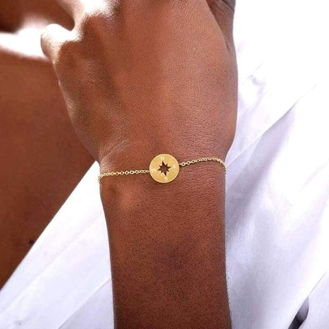 dainty compass bracelet, gold, on womens wrist