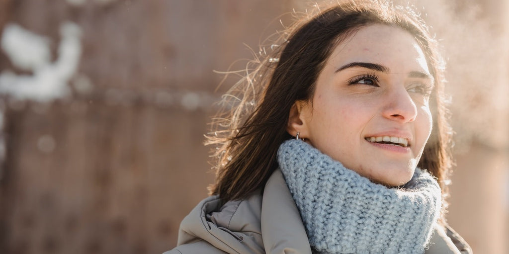 A happy person exhaling vapor outside.