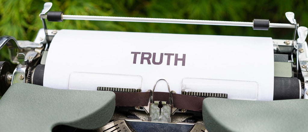 A typewriter with a sheet of paper saying "TRUTH" on it.