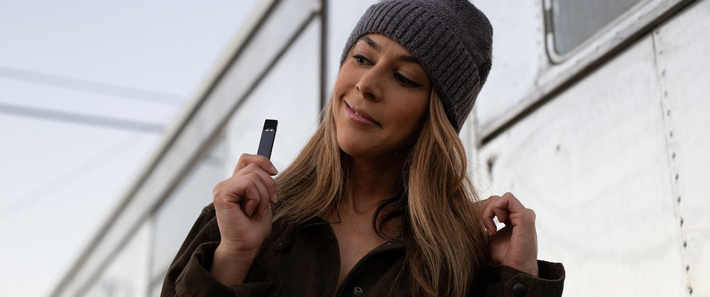 A person vaporizing using a dry herb vape outside.