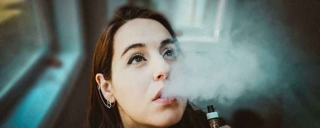 A person exhaling vapor from a vape pen.