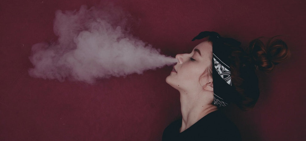 A person exhaling cannabis vapor from a vaporizer.