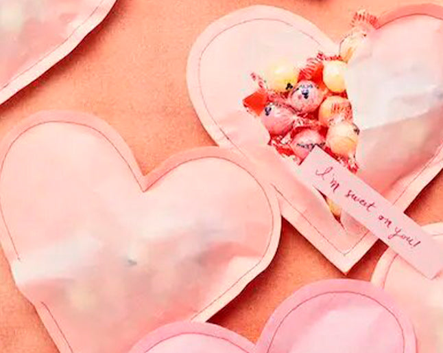 Foto de idea de manualidad infantil para San Valentín con corazones de papel llenos de dulces