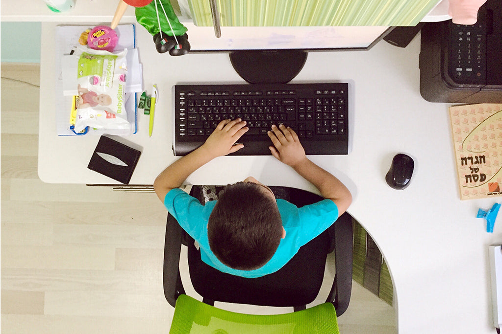 Niño trabajando en la computadora en clases virtuales en un estudio sin distracciones