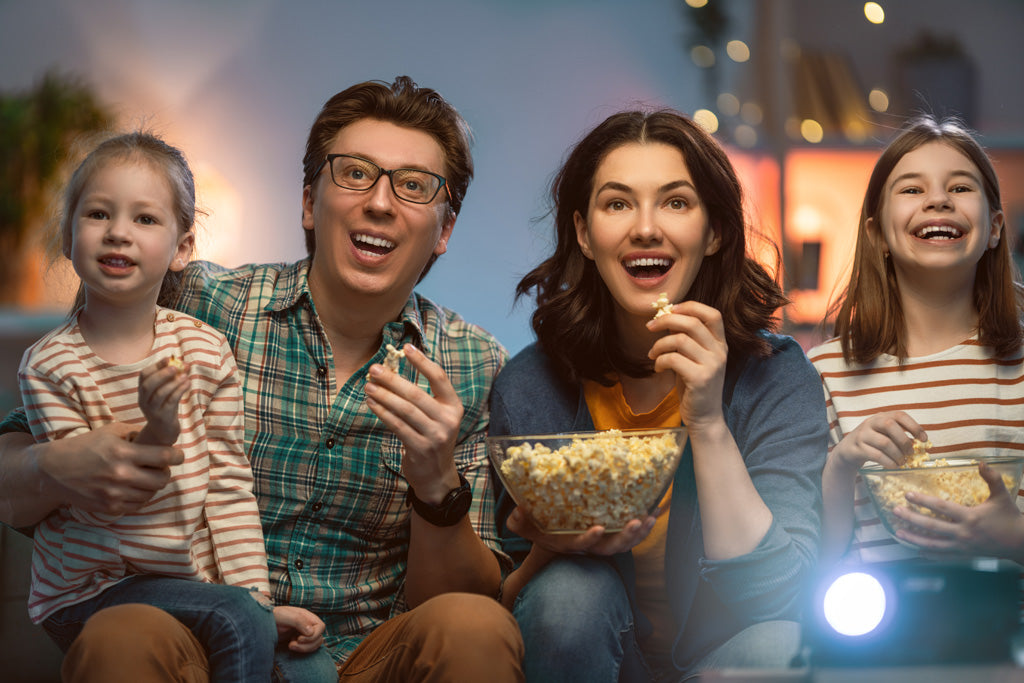Foto de familia con hijas viendo películas en la sala, noche de películas