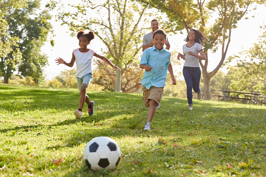 Foto de familia jugando football soccer en el parque