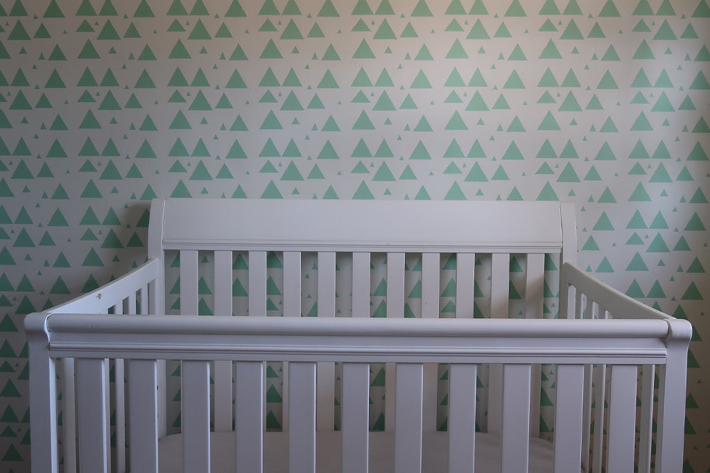 Foto de cuarto de bebé cuna blanca y papel tapiz decorado verde