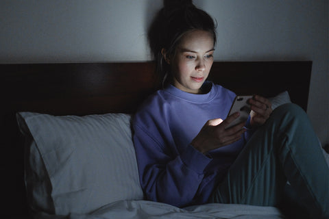 girl on cellphone in bed