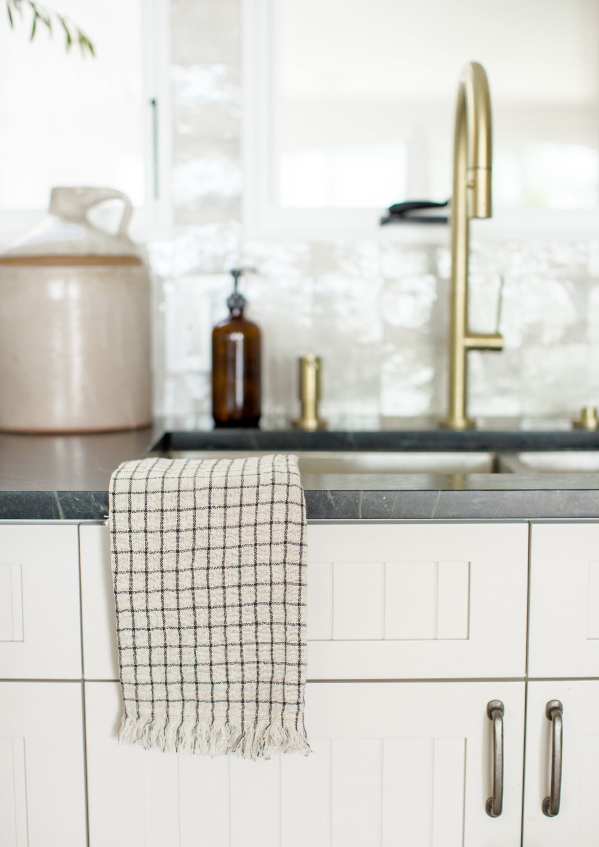 Brass and marble kitchen with black and white tea towel