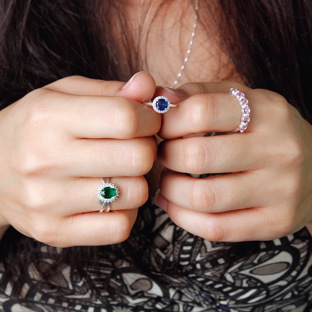 Mãos de uma jovem mulher usando vários aneis de prata.