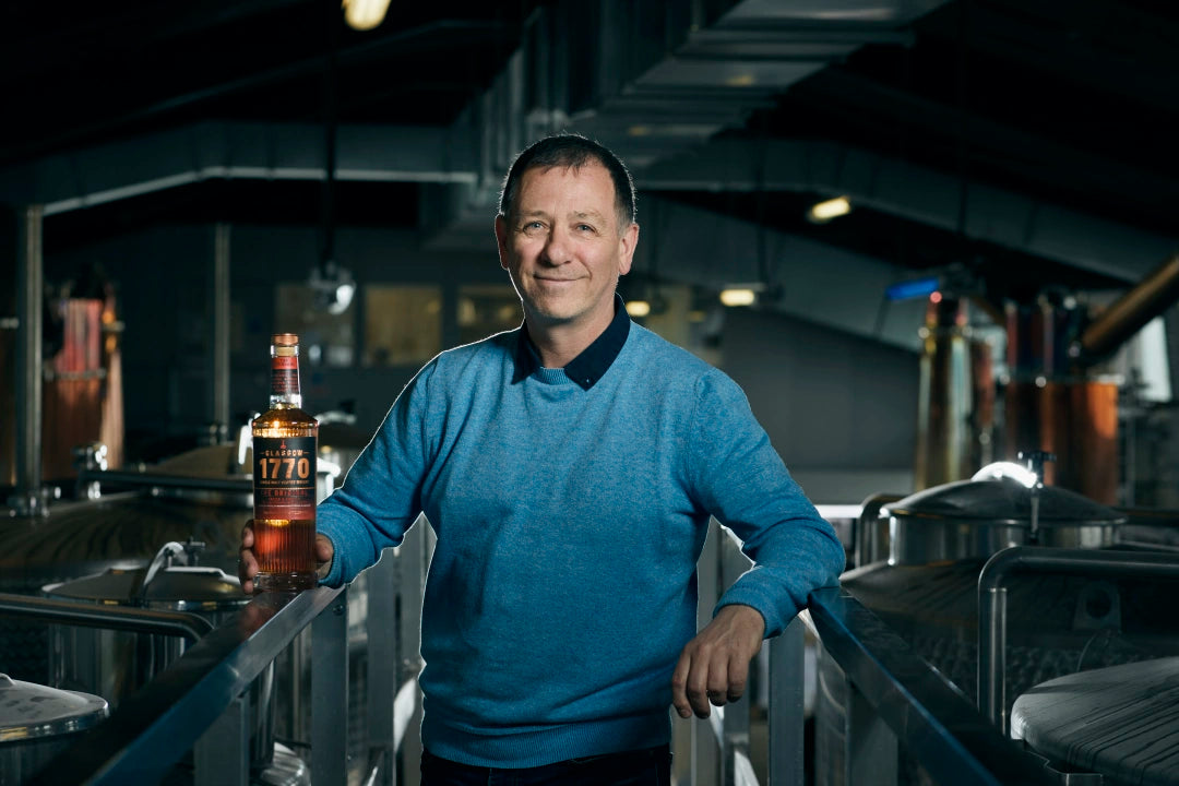 Liam Hughes Distillery Founder with 700ml whisky