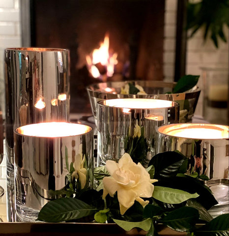 gardenia and lit candles in front of fireplace