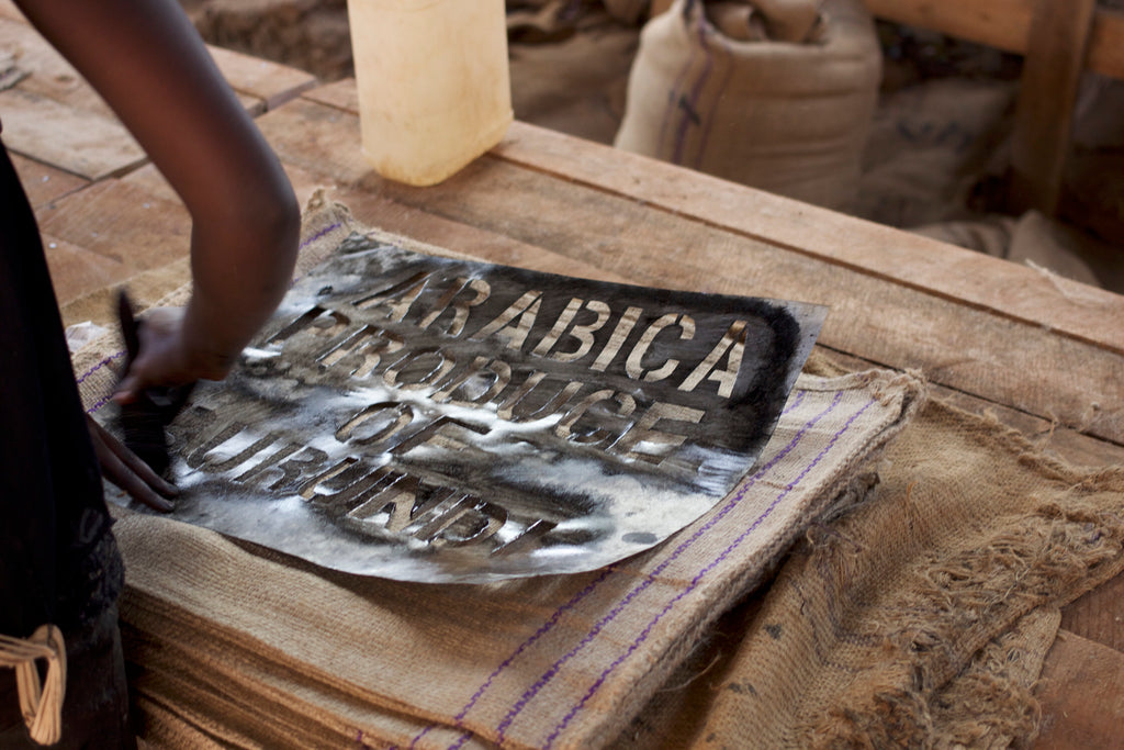 Hand painting sacks. Our coffee will always be shipped inside GrainPro, or another brand of protective liner before going into these traditional hessian sacks, to preserve quality and freshness.