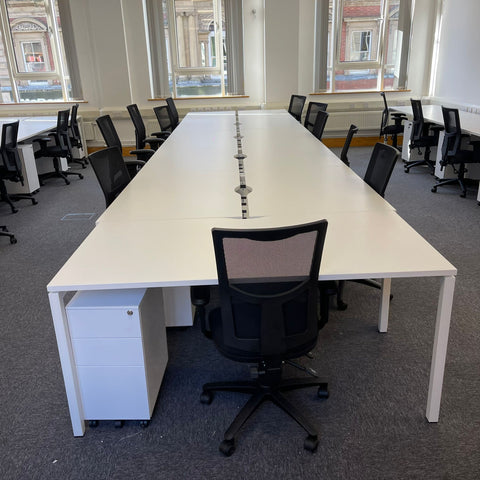 Second hand bench desks and black mesh chairs installed in a London office, 2022