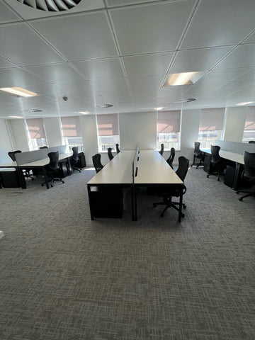 Side view of a six position used bench desk with pedestals and used office chairs in Richmond.