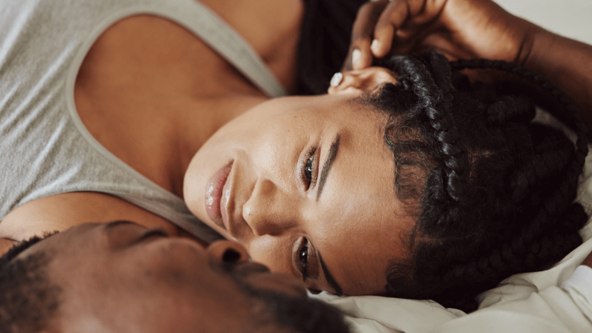 Woman looking deeply into the eyes of her partner in bed.