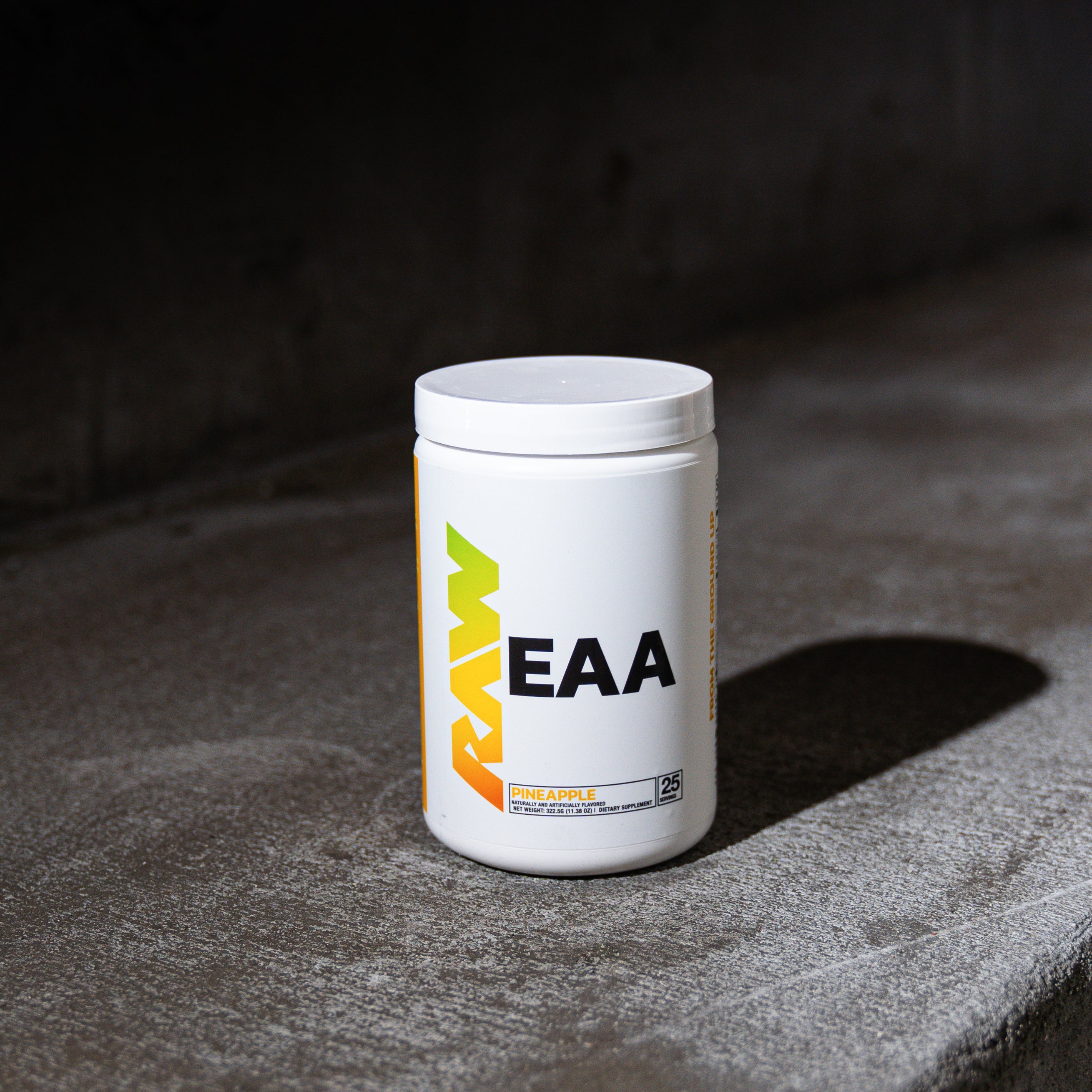 Container of EAA supplement on a concrete surface.