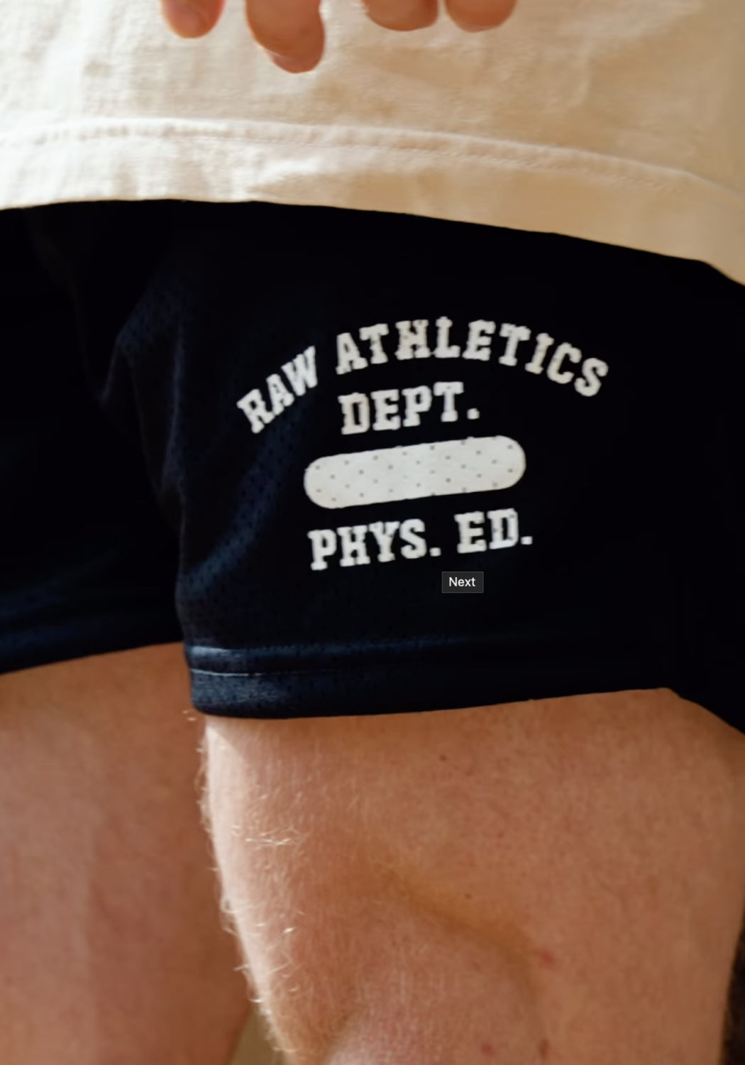 Close-up of shorts with 'Raw Athletics Dept. Phys. Ed.' written on them.